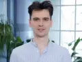 Piotr, w niebieskiej koszuli w paski, wygląda jakby właśnie skończył czytać książkę, a teraz opowiada o niej z pasją.