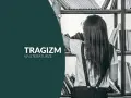 Dziewczyna w okularach szuka książki na półce. Napis "Tragizm w literaturze" sugeruje, że szuka odpowiedzi na pytanie: tragizm co to.