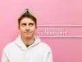 Młody mężczyzna z książką na głowie zastanawia się, czym jest dialektyzacja w literaturze.