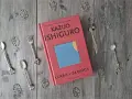 Książka "Klara i Słońce" Kazuo Ishiguro na drewnianym tle, otoczona ozdobnymi łyżeczkami i listkami.