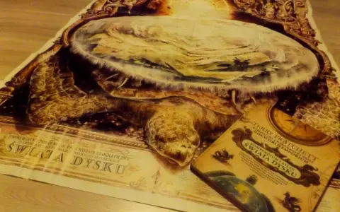 Mapa świata dysku z Wielkim A'Tuinem i książka Terry'ego Pratchetta "Świat Dysku".