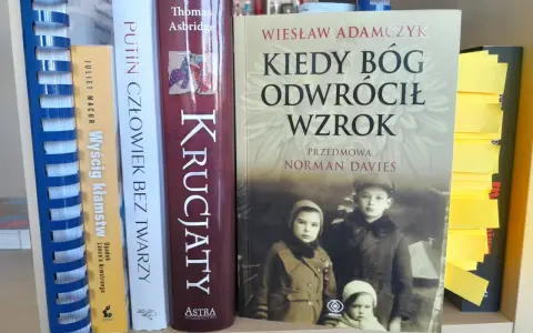 Okładka książki "Kiedy Bóg odwrócił wzrok" z portretem dzieci. Obok inne książki, w tym "Putin człowiek bez twarzy".