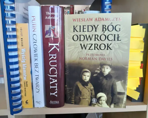 Okładka książki "Kiedy Bóg odwrócił wzrok" z portretem dzieci. Obok inne książki, w tym "Putin człowiek bez twarzy".