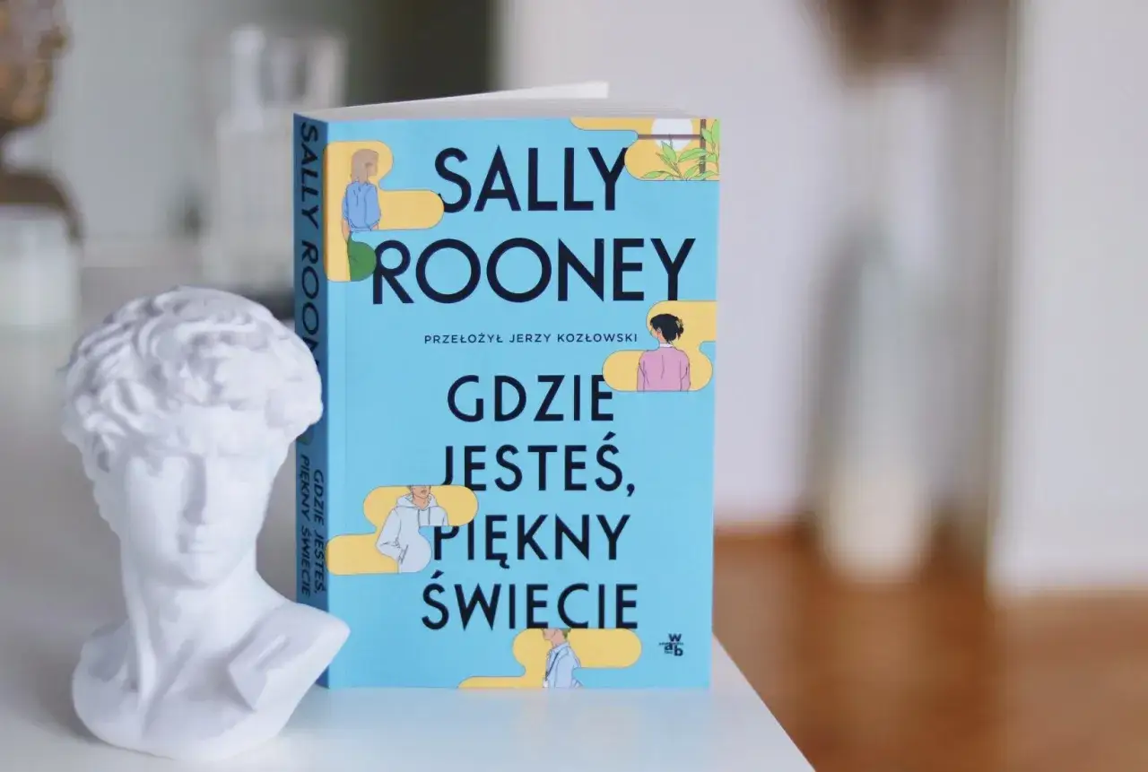 Biała rzeźba głowy i książka Sally Rooney 