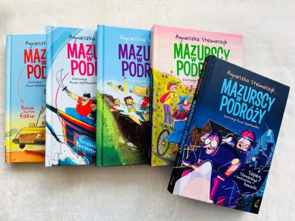 Książki "Mazurscy w podróży" z ilustracjami Anny Oparkowskiej. Wesołe przygody na okładkach zachęcają do lektury.